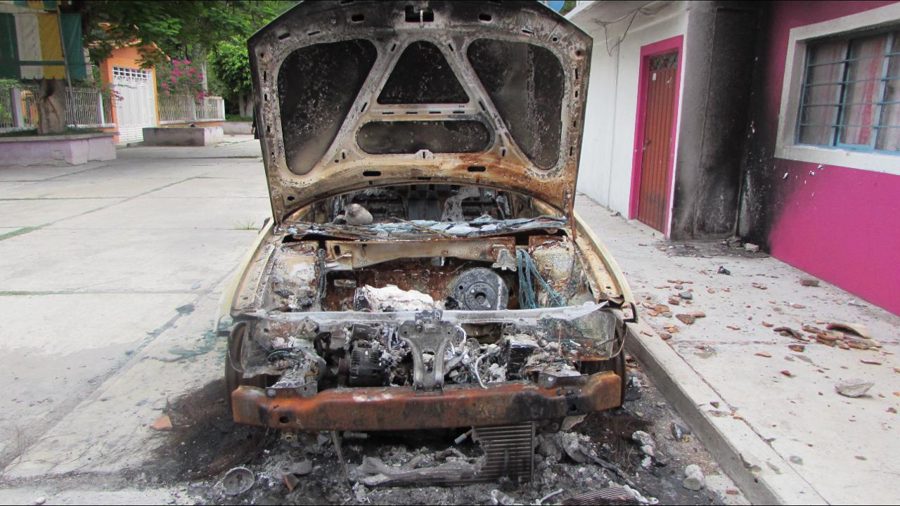 Vehículo calcinado en una calle de la Mixteca