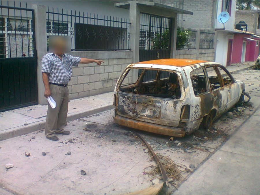 Un hombre señala una camioneta calcinada